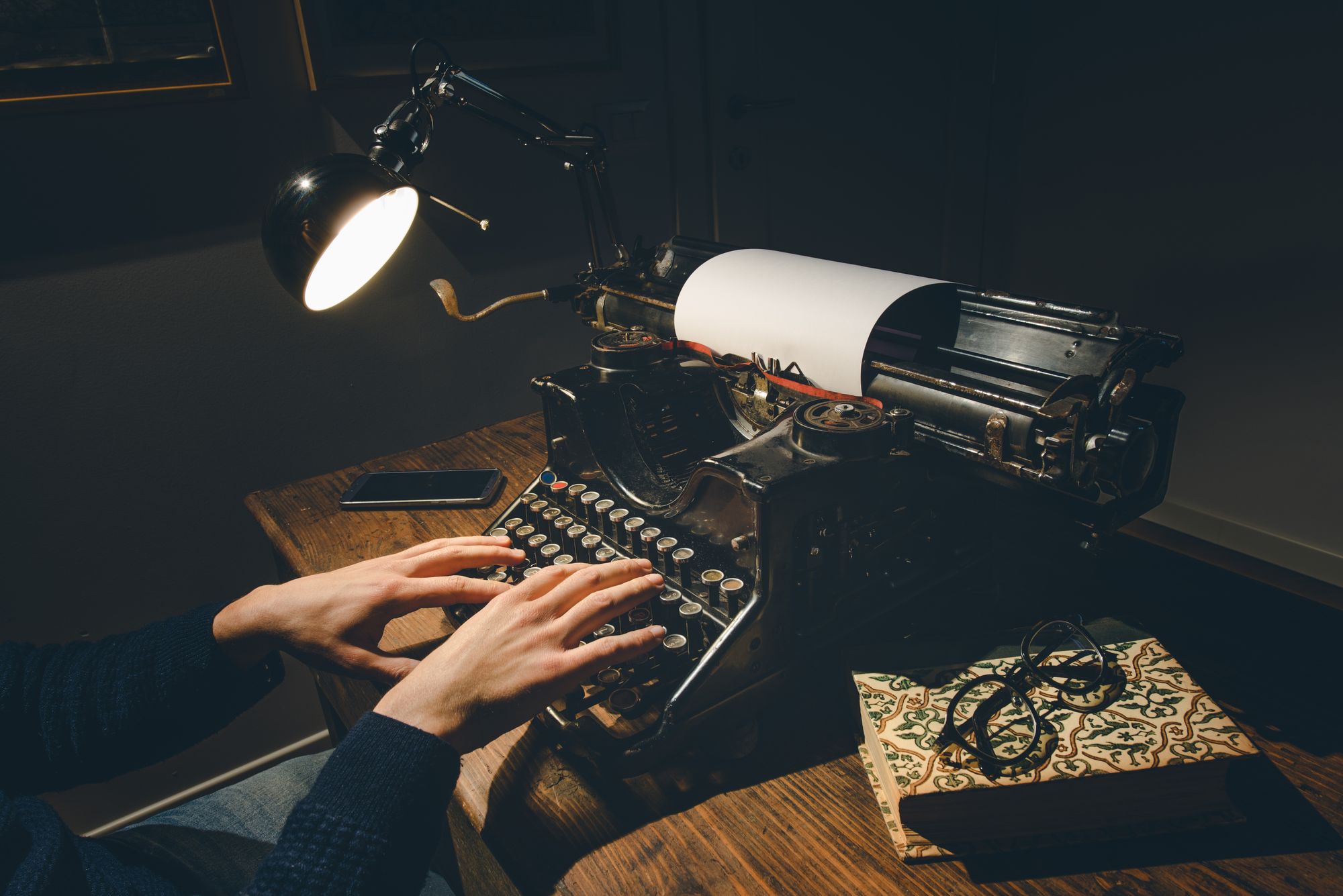 Hands writing on a vintage typewriter