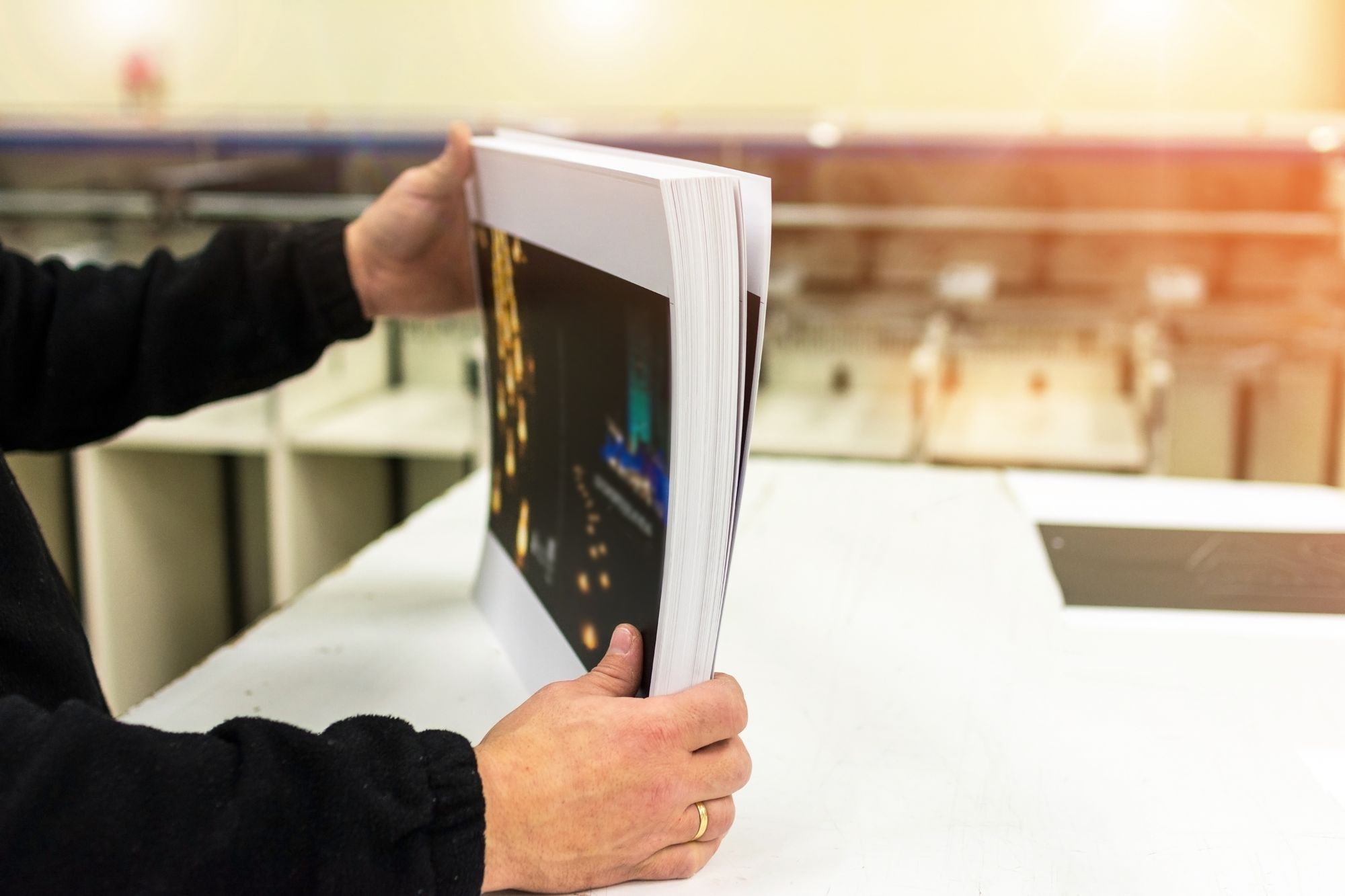 Hands holding a stack of freshly printed postcards