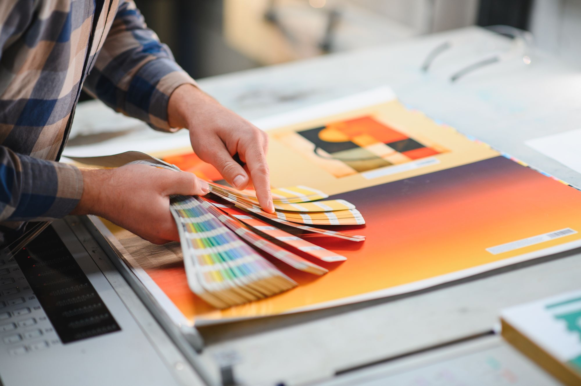 Printer checking color swatches on a freshly printed sheet